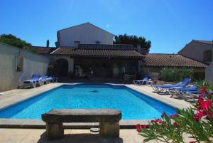 einen Pool mit Stühlen und ein Haus in der Unterkunft Gite le Mas de l'Amandier in Saint-Saturnin-lès-Avignon