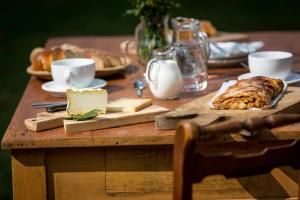 a wooden table with bread and cheese on it at Rifugio Uschione in Chiavenna