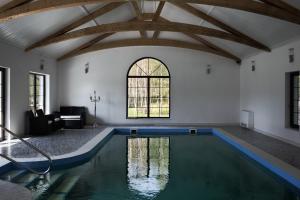 an indoor pool in a room with a ceiling with beams at Martiany 21 in Martiany