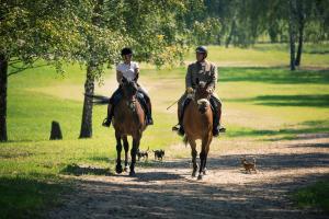 two people riding horses on a path with dogs at Martiany 21 in Martiany