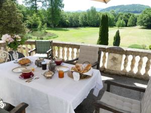 uma mesa com comida e vista para um campo de golfe em Chateau du Val Larbont em La Bastide-de-Sérou