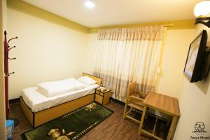a bedroom with a bed and a television and a table at Aarya Chaitya Inn in Kathmandu