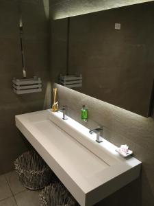 a bathroom with a white sink and a mirror at Garnì Tobià in Campitello di Fassa