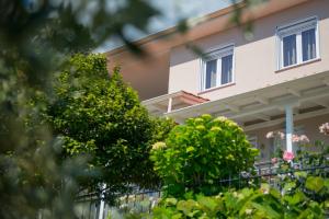a pink house with trees in front of it at Villa Roula in Koinyra