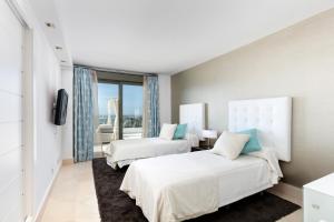 2 łóżka w pokoju hotelowym z oknem w obiekcie Los Flamingos Tee 6 w mieście Estepona