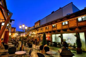 an empty street with tables and chairs at night at Downtown Apartment Klaipeda in Klaipėda