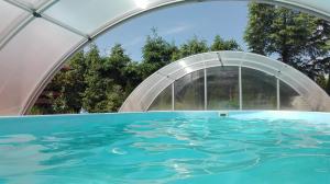 a swimming pool with a plastic tunnel over it at Villa Marina in Dąbki