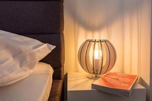 a lamp and a book on a table next to a bed at Apartment St Johannis in Nürnberg