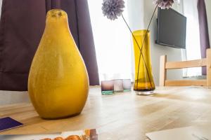 a yellow vase and two vases on a table at Apartment St Johannis in Nürnberg
