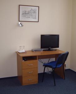 a desk with a computer monitor and a chair at Parkhotel Terezín in Terezín