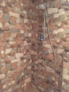 a bathroom with a shower with a stone wall at Guest House Adriatica by Pinch in Pakoštane +24 photos