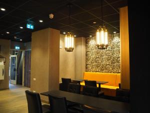 a dining room with tables and chairs and chandeliers at Blossoms City Hotel in Amsterdam