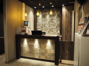 a lobby with a counter and a wall with lights at Blossoms City Hotel in Amsterdam