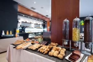 a buffet with bread and pastries on a table at Exe Cuenca in Cuenca