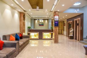 a lobby of a hospital with couches and a statue at Hotel Heritage - Near Navrangpura in Ahmedabad