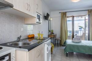 a kitchen with a sink and a living room at Ritsa Studios in Skiathos Town