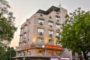a tall pink building with windows on a street at Hotel Heritage - Near Navrangpura in Ahmedabad