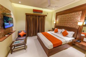 a hotel room with a bed and a television at Hotel Heritage - Near Navrangpura in Ahmedabad +25 photos