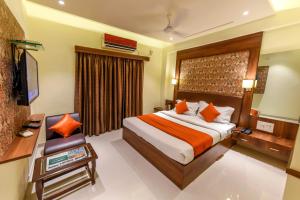 a hotel room with a bed and a television at Hotel Heritage - Near Navrangpura in Ahmedabad