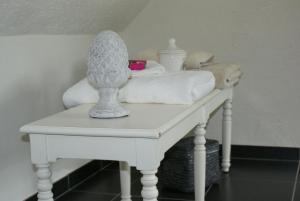 Una mesa blanca con toallas y un jarrón. en Chambres d'Hôtes de la Boire Bavard, en Blaison