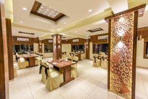 a restaurant with tables and chairs in a room at Hotel Heritage - Near Navrangpura in Ahmedabad
