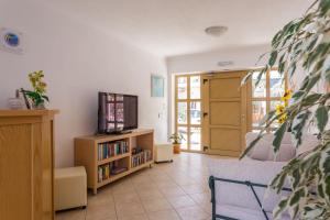 a living room with a couch and a tv at Ritsa Studios in Skiathos Town