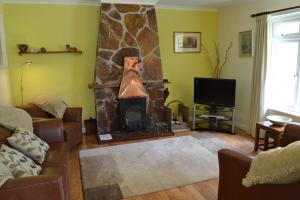 a living room with a fireplace and a tv at Nanis in Crantock