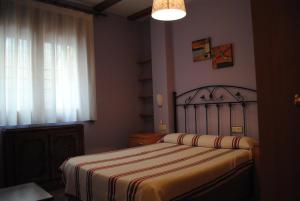 a bedroom with a bed with a striped blanket at APARTAMENTOS RIO MORA 2 in Mora de Rubielos