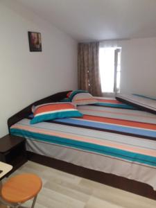 クルテア・デ・アルジェシュにあるCasa Arianaのベッドルーム1室(カラフルな枕と窓付)