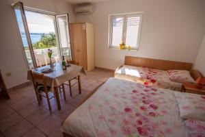 a bedroom with two beds and a table with a tableablish at Apartments Bella Poljana in Ugljan