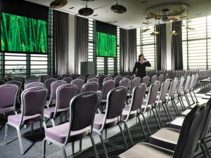 un homme debout dans une pièce avec rangées de chaises dans l'établissement The Gibson Hotel, à Dublin