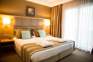 a bedroom with a large bed with a large window at Efeler Hotel in Aydın