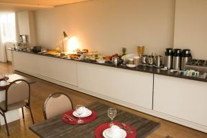 a kitchen with a counter with a table and chairs at Select Hotel in Palmas