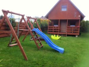 a playground with a slide in the grass at Domki Mantras in Swarzewo