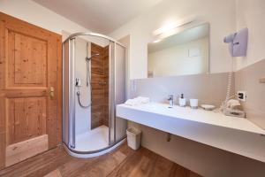 a bathroom with a shower and a sink and a mirror at La Cianò in Corvara in Badia