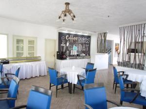 a dining room with white tables and blue chairs at Castello in Limenaria