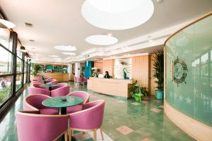 a restaurant with purple chairs and tables and a counter at Hotel Levante in Bellaria-Igea Marina