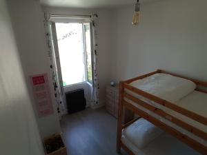 ル・シャトー・ドレロンにあるAdopt'îleの二段ベッド1組、窓が備わる小さな客室です。