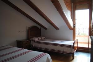 sypialnia z 2 łóżkami i oknem w obiekcie Abuelo Duplex w mieście Mora de Rubielos