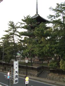 a pagoda with a sign in front of a street at Daibutsukan in Nara