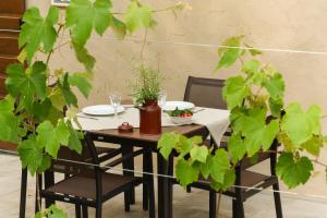 una mesa y sillas con una mesa y plantas en Cascina Varini en Gargnano