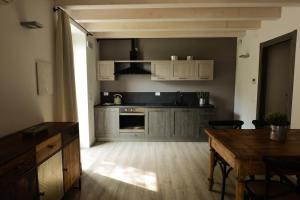 a kitchen with white cabinets and a wooden table at Cascina Varini in Gargnano