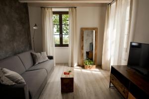 ein Wohnzimmer mit einem Sofa und einem TV in der Unterkunft Cascina Varini in Gargnano