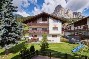 a house in the mountains with a playground at La Cianò in Corvara in Badia