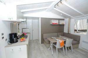 - une salle à manger et une cuisine avec une table et des chaises dans l'établissement Camping Le Parc, à Saint-Paul-en-Forêt