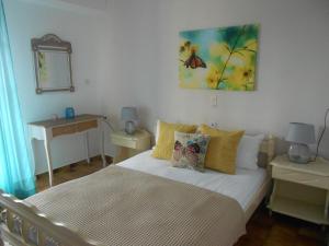 a bedroom with a bed and a butterfly painting on the wall at Stella Studios in Patitiri