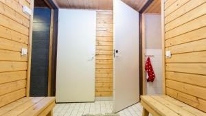 un bagno con pareti rivestite in legno e una porta di Riihipiilo a Moksinkylä
