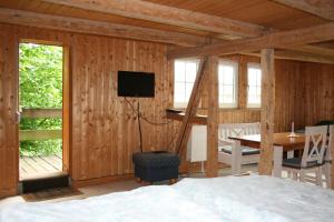 Schlafzimmer mit einem Bett, einem Tisch und einem TV in der Unterkunft Apartments Café Brennnessel in Veltheim