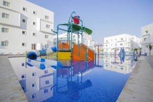 Un parque infantil en el agua junto a un edificio. en L'escale Appart-hôtel By 7AV HOTELS, en M'diq