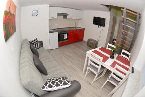 een woonkamer en een keuken met een bank en een tafel bij Apartment April in Bled